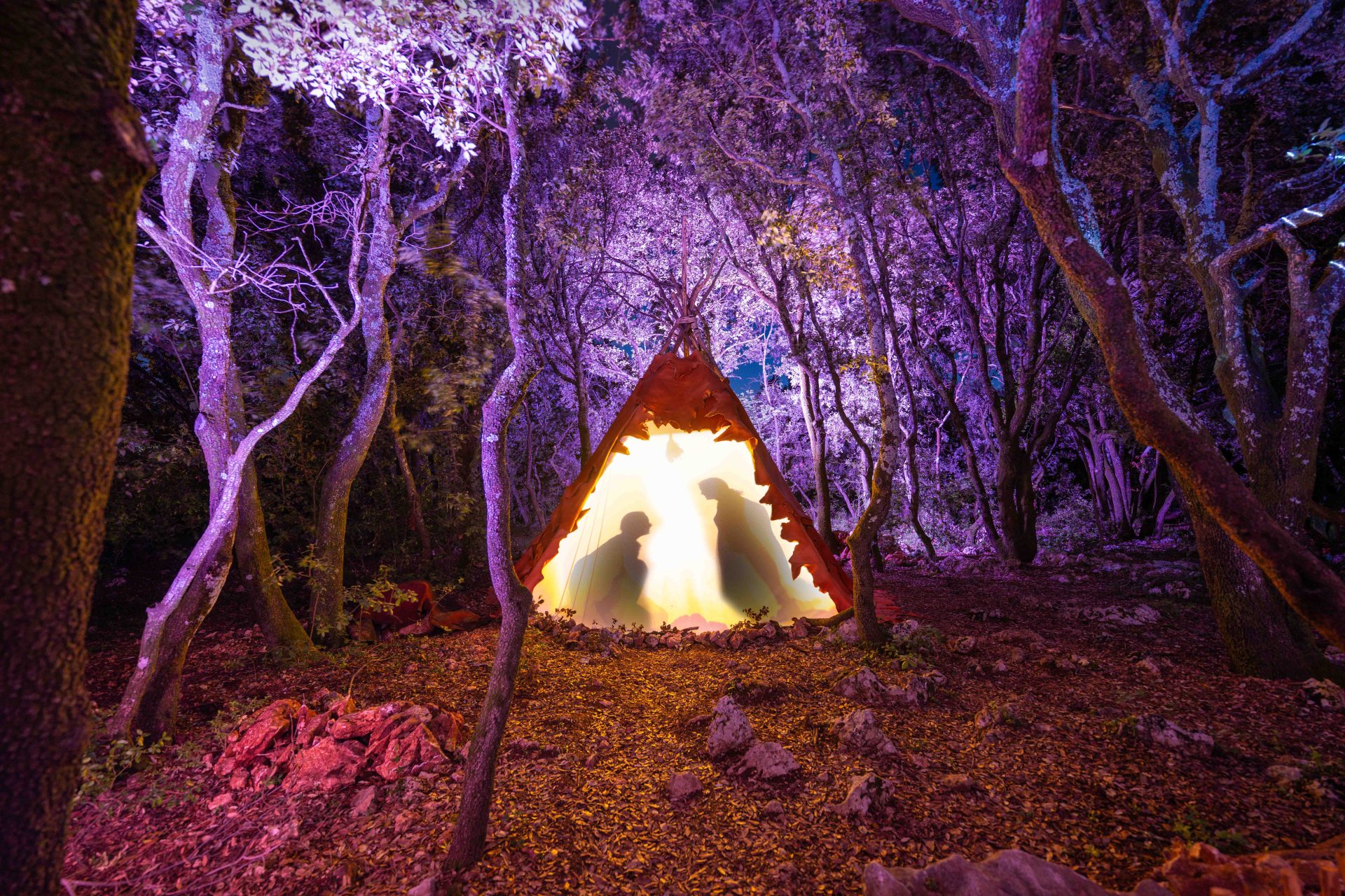 Le campement paléolithique à la nuit tombée : des jeux d'ombres et de lumières dans l'intimité des tentes, où les artistes se préparent.