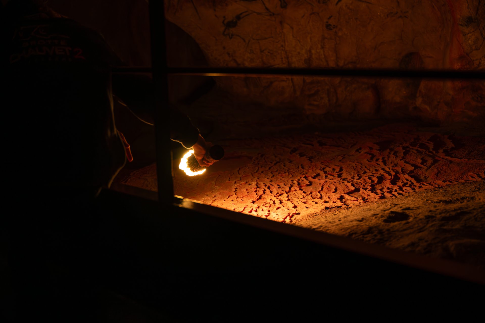 Les reliefs de la grotte, les détails des sols et parois se révèlent à la lumière de la torche.